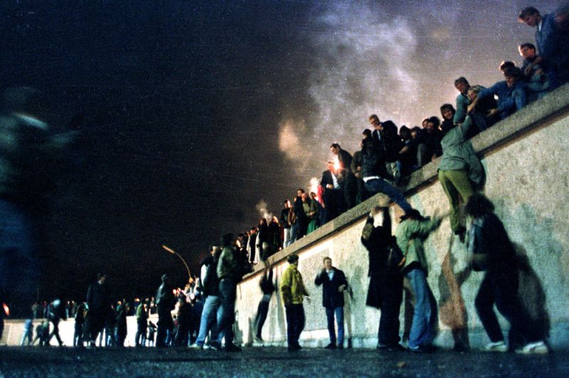 Жители Восточной и Западной Германии у Берлинской стены в районе Бранденбургских ворот.