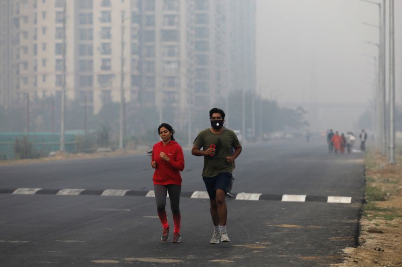 Люди на утренней пробежке на окраине Нью-Дели.