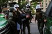 Полицейские задерживают демонстранта во время акции протеста против правительства в одном из районов Сантьяго, Чили.