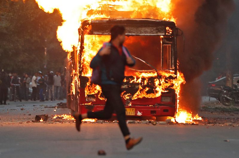 Автобус, который был подожжен демонстрантами во время протестов против нового закона о гражданстве в Нью-Дели.