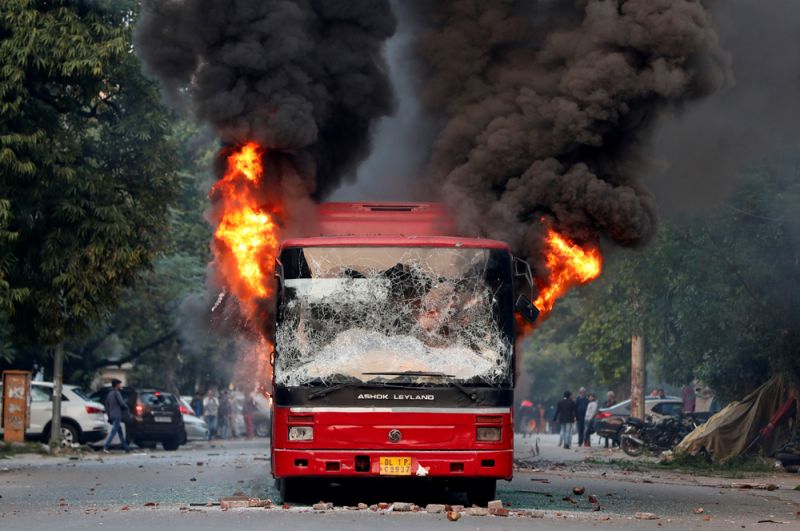 Автобус, который был подожжен демонстрантами во время протестов против нового закона о гражданстве в Нью-Дели.