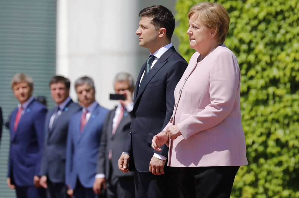Канцлер Германии Ангела Меркель и президент Украины Владимир Зеленский во встречи в Берлине. Во время исполнения гимнов двух стран Меркель испытала приступ сильной дрожи. Это случилось с ней во второй раз, однако канцлер заверила журналистов, что с ней все в порядке. Недомогание, по ее словам, было вызвано обезвоживанием: в тот день в Берлине было аномально жарко.