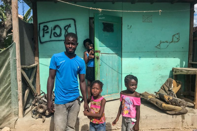 Семья перед своим домом в общине Ханаан на окраине Порт-о-Пренса. Ханаан был создан после землетрясения, сегодня там живет около 300 тысяч человек.