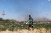 Сомалийский фермер разгоняет пустынную саранчу на поле.