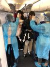 Медики измеряют температуру пассажиров на борту рейса Air China из Уханя в Макао.
