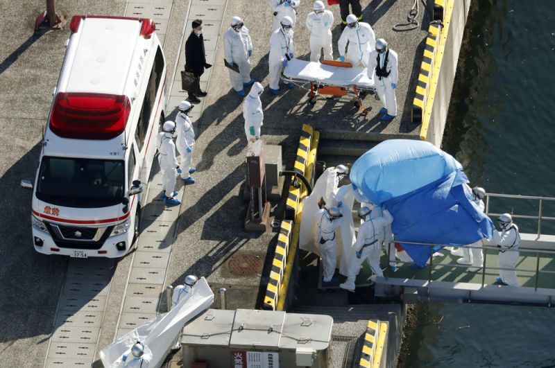 Работники скорой помощи госпитализируют заболевшего коронавирусом с лайнера Diamond Princess.