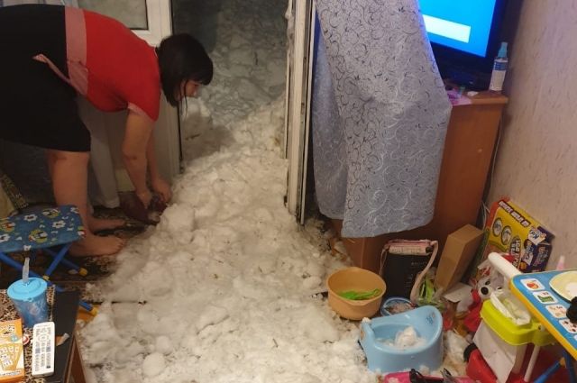Жители выгребают залетевший в квартиру снег.