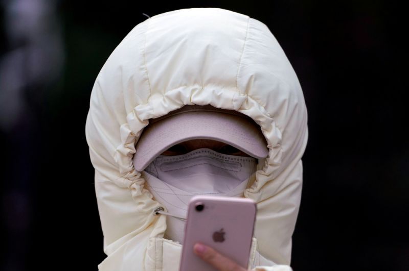 Женщина проверяет свой мобильный телефон, Шанхай.