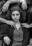 15-летняя армянская девушка, которая недавно вышла из кататонического ступора, в окружении родственников в центре приема беженцев в Подкове-Лесьне, Польша.