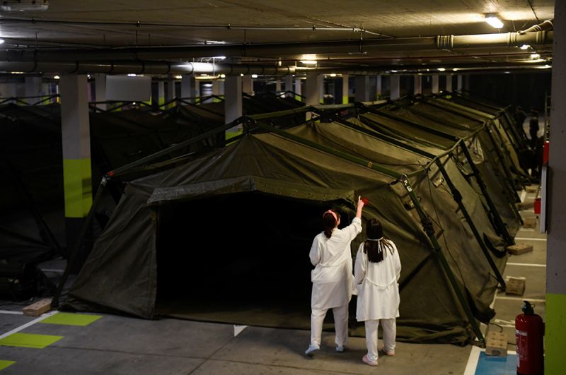 Служащие военного подразделения по чрезвычайным ситуациям (UME) устанавливают палаточный госпиталь на подземной стоянке в больнице Universitario Central de Asturias в Овьедо.