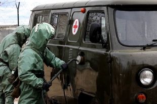 Военнослужащие войск радиационной, химической и биологической защиты проводят обработку поверхностей в ходе проверки готовности войск к возникновению угрозы заражения вирусными инфекциями.