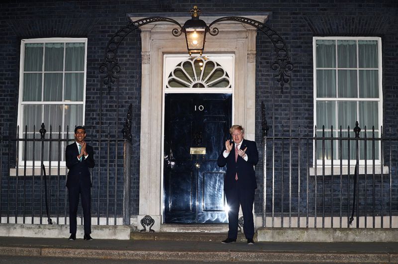 Премьер-министр Великобритании Борис Джонсон и канцлер казначейства Риши Сунак аплодируют медикам на Даунинг-стрит, 10, Лондон.