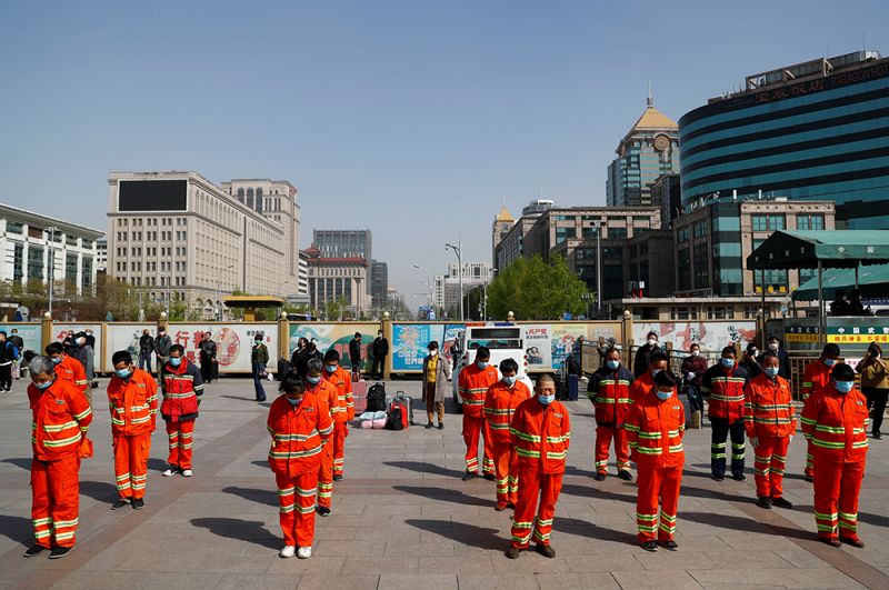 Уборщики улиц во время минуты молчания в Пекине.