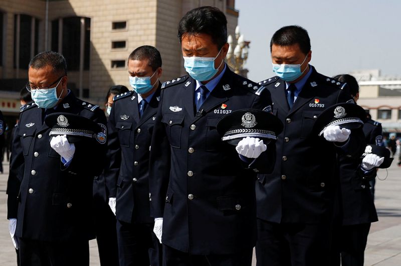 Охранники во время минуты молчания в Пекине.