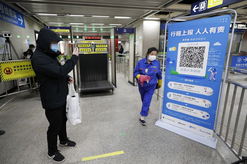 Пассажир сканирует QR-код перед входом в метро в Ухане.