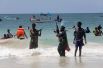Полицейский пытается разогнать купающихся на пляже Лидо в Могадишо, Сомали.
