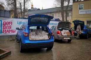 Волонтёры загружают автомобили, чтобы доставить помощь нуждающимся.