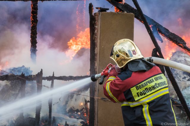 Пожарные рискуют жизнью, чтобы потушить огонь.