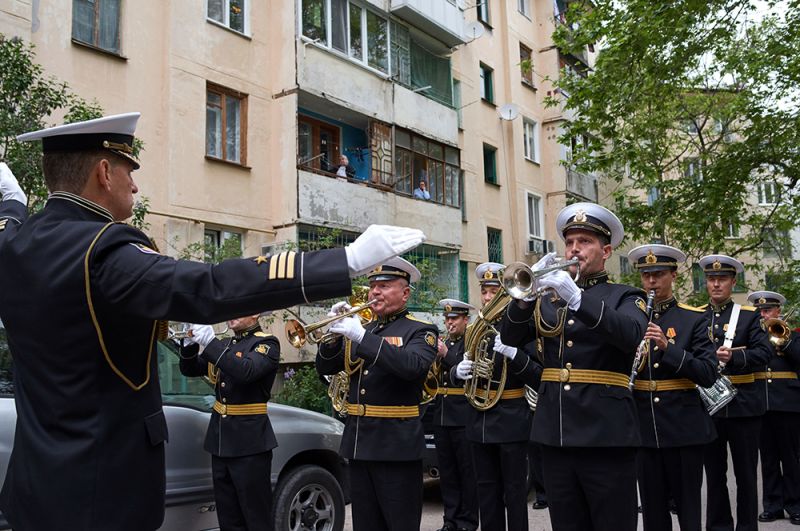 Участники персонального парада для ветерана Великой Отечественной войны, капитана 1-го ранга Луки Ивановича Кузина во дворе его дома в Севастополе.