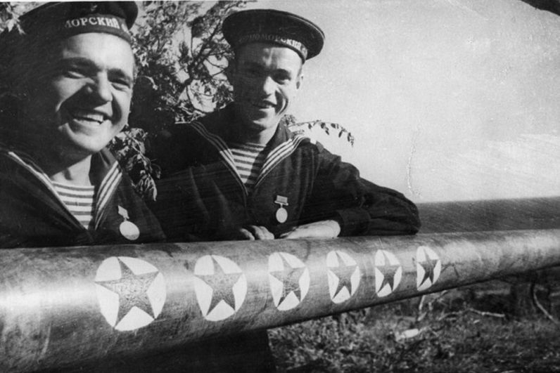 Новороссийские моряки-артиллеристы у ствола орудия с победными отметками.