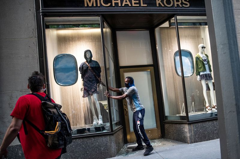 Люди грабят магазин брендовой одежды на Манхэттене в Нью-Йорке.