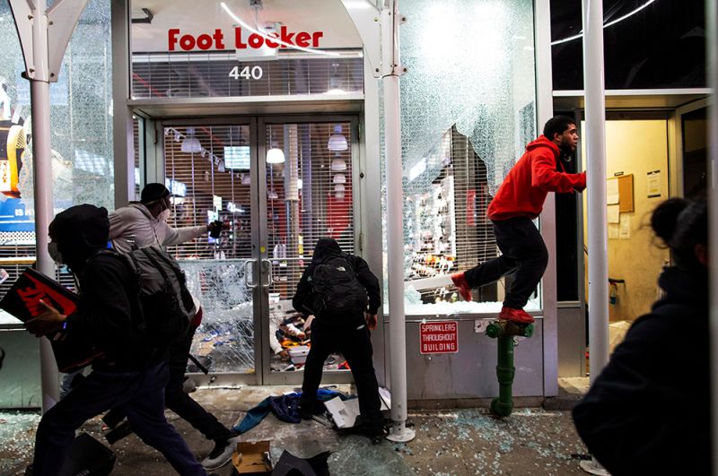 Люди грабят магазин на Манхэттене в Нью-Йорке.