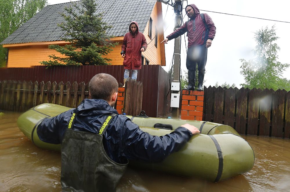 Спасатель эвакуирует жителей дачного поселка, подтопленного из-за разлива реки Воря в Щелковском районе Московской области.