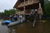 Жители дачного поселка на лодке возле своего дома, подтопленного из-за разлива реки Воря в Щелковском районе Московской области.