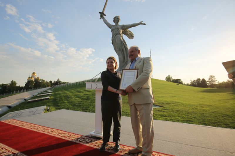 Министр культуры РФ Ольга Любимова вручает благодарность участнику разработки проекта реставрации монумента «Родина-мать зовет!» директору Волгоградского филиала Научно-исследовательского института энергетических сооружений Геннадию Мажбицу.