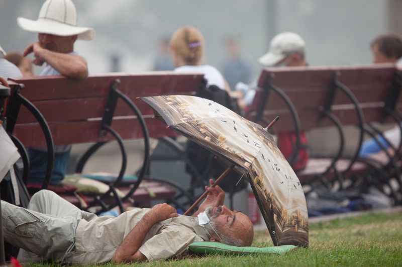 Мужчина отдыхает на газоне летом 2010 года.