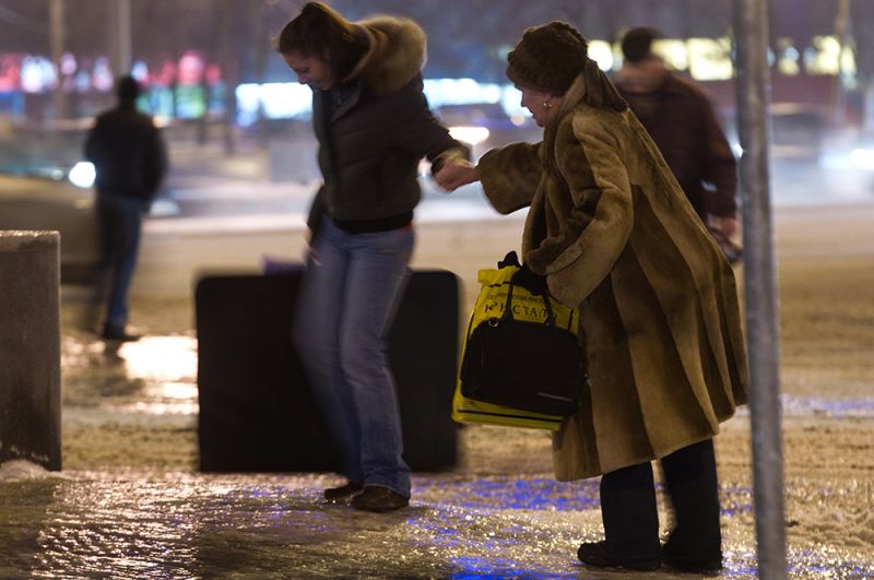 Улицы после прошедшего ледяного дождя превратились в один сплошной каток. На фото: жители Москвы идут по тротуару, покрытому льдом, на Ленинском проспекте. 