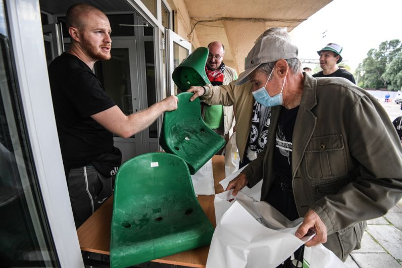 Футбольные болельщики забирают на память сиденья.