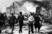 Японцы выносят жертву взрыва из дымящихся руин в Хиросиме, Япония, 6 августа 1945 года.