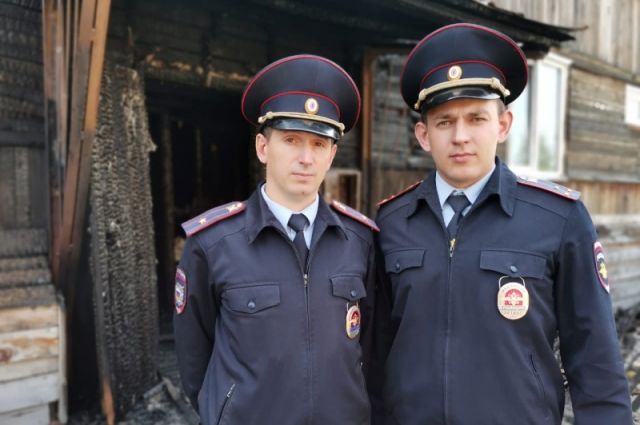 Майор полиции Евгений Филиппов и старший лейтенант полиции Анатолий Окунев вынесли женщину из горящего дома.