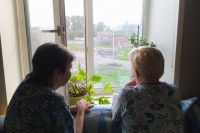 Ирина Кузьмина с соседкой смотрит в окно на горящую свалку.