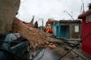 Спасатели ищут людей в обломках после того, как из-за шторма обрушилась стена дома в Санто-Доминго, Доминиканская Республика.