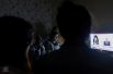 Люди смотрят телевизор в бомбоубежище в Степанакерте.