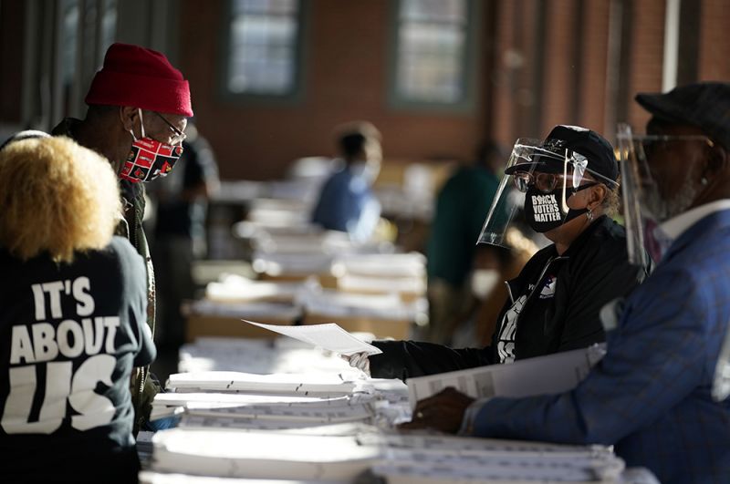 Сотрудники избирательной комиссии раздают бюллетени в Центре афроамериканского наследия во время президентских выборов в США в Луисвилле, штат Кентукки.