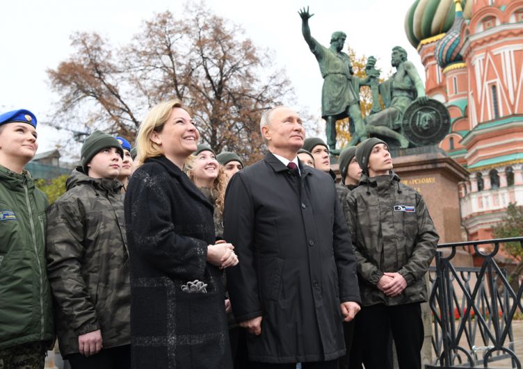 Президент РФ Владимир Путин вместе с представителями молодежных организаций слушают обновленный звон колоколов на Спасской башне Кремля. 
