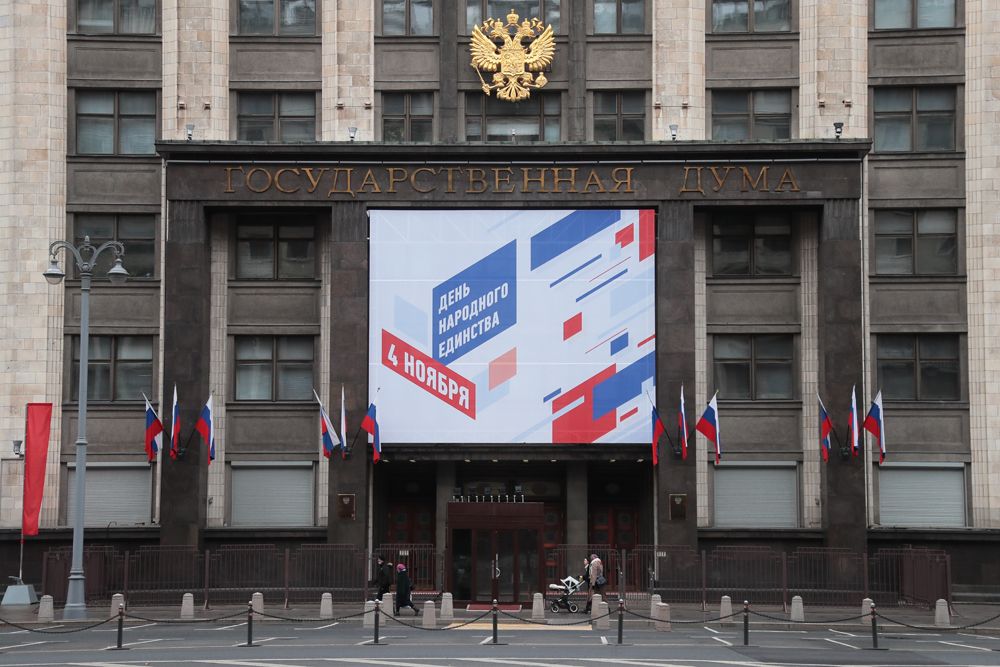 Здание Государственной Думы РФ в Москве, украшенное флагами и баннером в цветах триколора в честь празднования Дня народного единства.