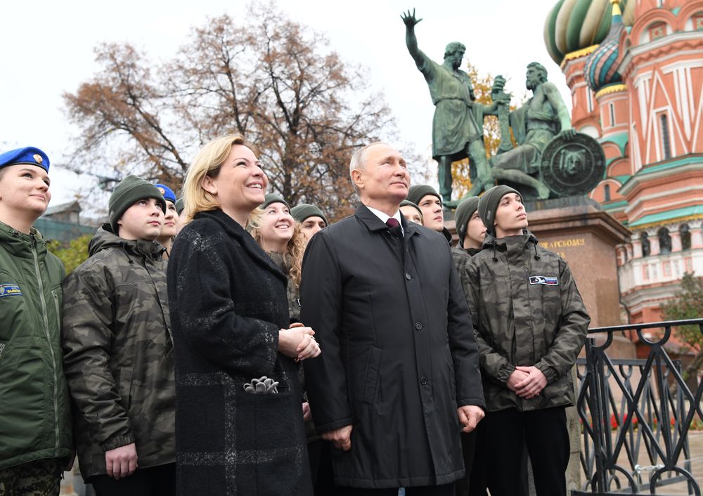 Президент РФ Владимир Путин вместе с представителями молодежных организаций слушают обновленный звон колоколов на Спасской башне Кремля.