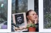 Жительница Иркутска на балконе с портретом своего родственника - ветерана Великой Отечественной войны в рамках акции «Окна Победы».