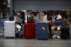Путешественники с чемоданами в терминале аэропорта.