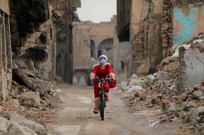 Женщина в костюме Санта-Клауса в Мосуле, Ирак.