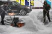 Мужчины убирают снег во время снегопада во Владивостоке.