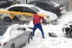 Мужчина откапывает из сугроба свою машину во дворе жилого дома в Москве.