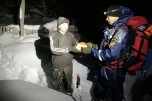 Спасатели передают хлеб жителям поселка, к которому сейчас не добраться на транспорте.