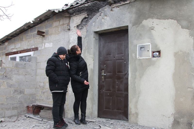 Жительница поселка Еленовка показывает свой дом, поврежденный артобстрелом.