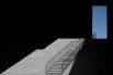 Klaus Lenzen (Германия). Фотография лестницы в отеле Hyatt в Дюссельдорфе, поднимающейся к окну, из которого отражается вид на чистое голубое небо. Лестница и окно кажутся парящими в пространстве, обрамлены темными тенями, которые подчеркивают дизайн, а также добавляют элемент сюрреализма.