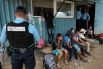 Полицейский Гондураса проверяет документы мигрантов, идущих в США, на пограничном переходе с Гватемалой.